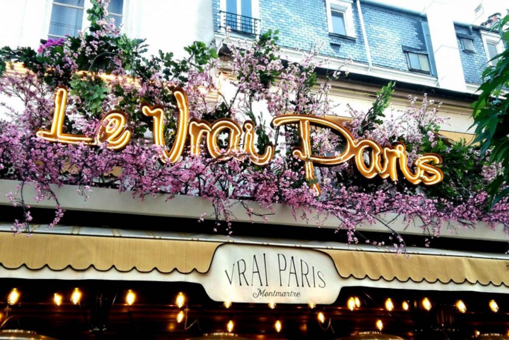 Kvetinová výzdoba nad vstupom do kaviarne Le Vrai Paris